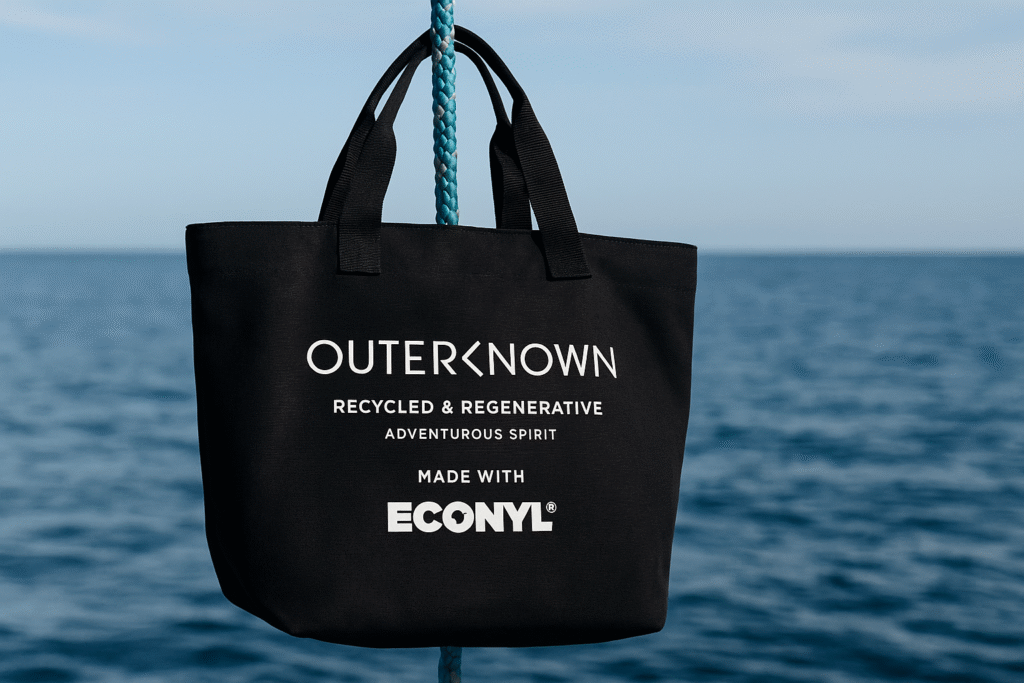 alt text: Outerknown t-shirt made from recycled fishing nets, with ocean backdrop