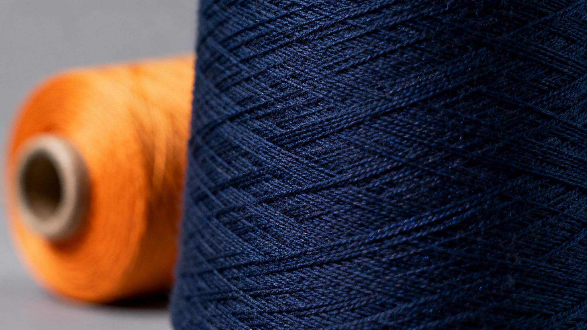 Macro photograph of a navy cotton-polyester blend knit fabric with fine even weave and subtle sheen